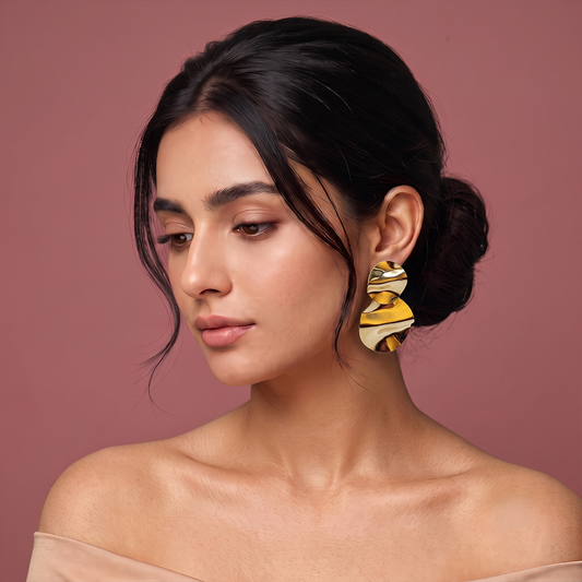 Gold plated statement drop earrings with textured double-disc design worn by a woman