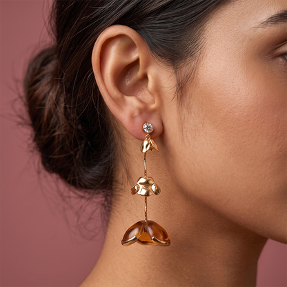 Gold plated floral drop earrings with crystal stud, delicate chain and amber flower charms worn on ear