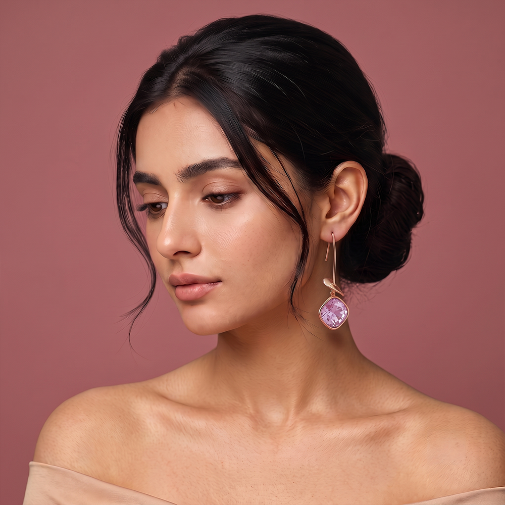 Gold plated drop earrings with lavender gemstone, delicate leaf accent and long hook design worn by a woman