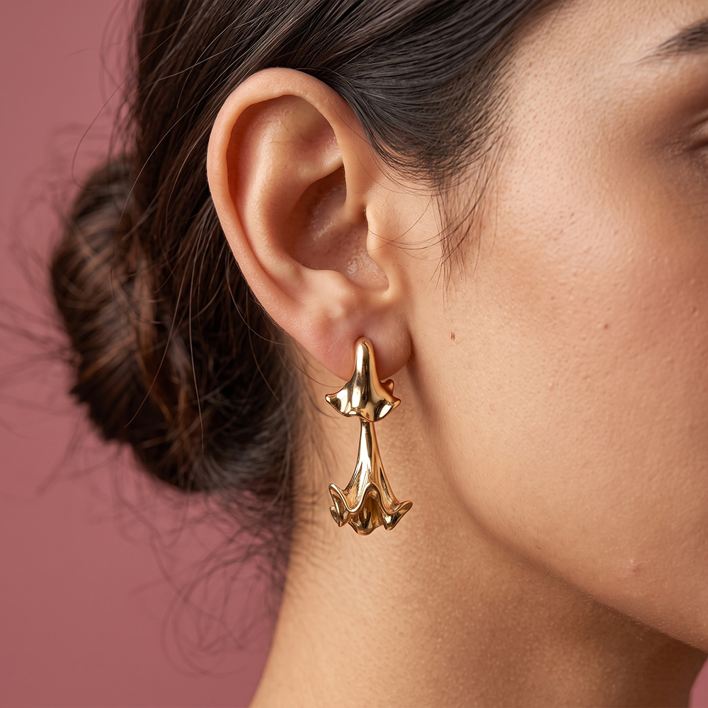 Gaurangi gold plated statement drop earring worn on woman's ear in close-up