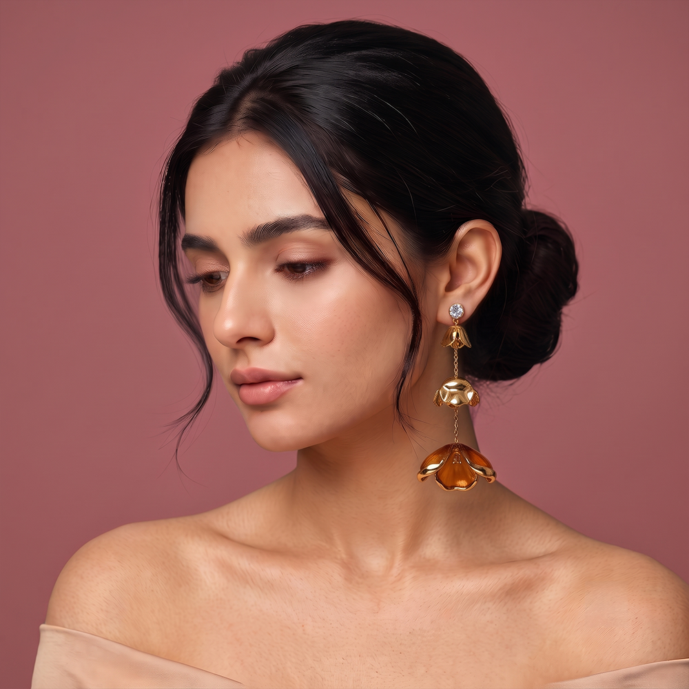 Gold plated flower drop earrings with crystal stud and long floral charms styled on a woman