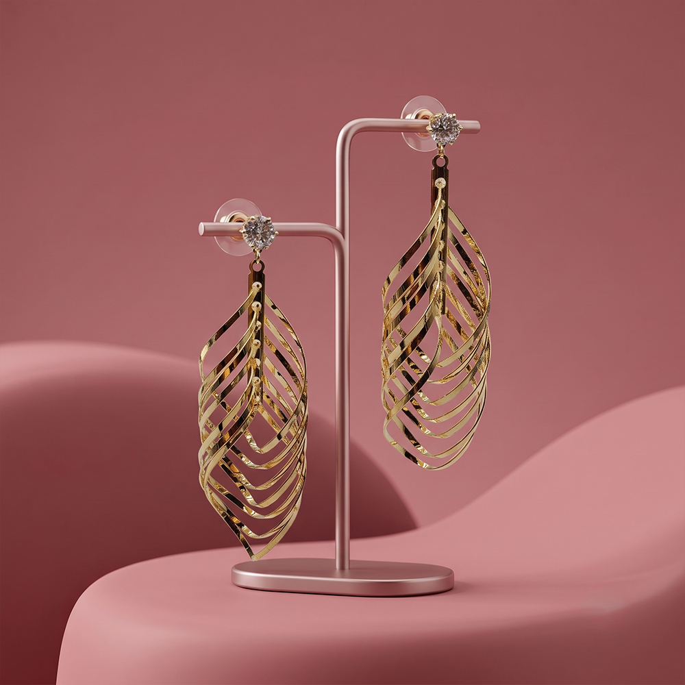 Gold plated leaf shaped drop earrings with crystal stud and intricate layered curved metal design displayed on a jewelry stand