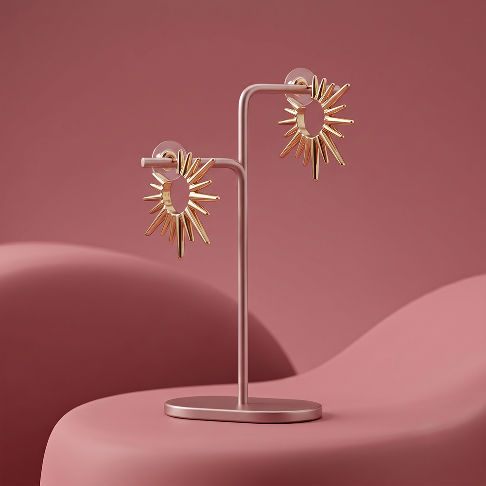Gold plated sunburst statement stud earrings with radiating polished metal spikes displayed on a jewelry stand