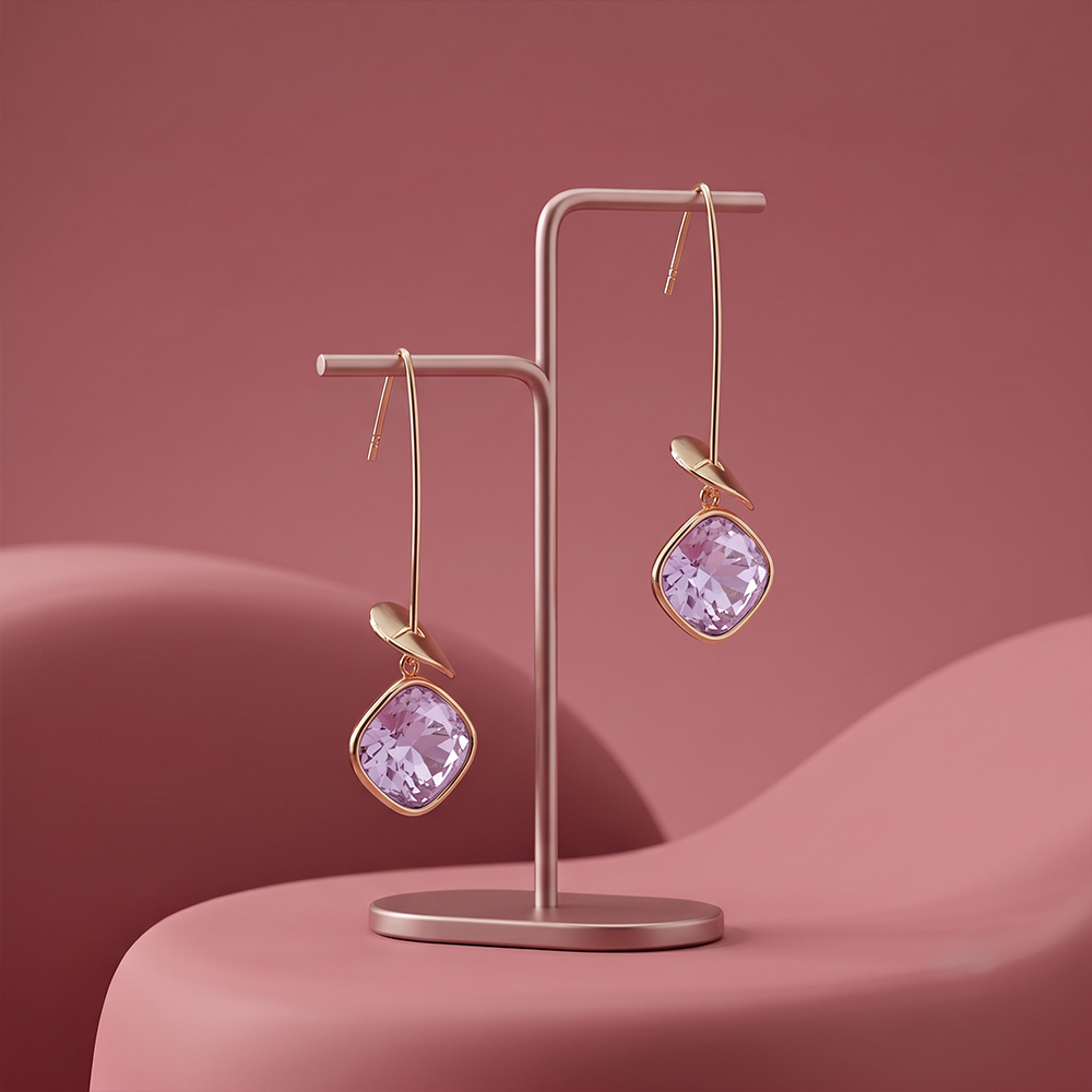 Gold plated lavender gemstone drop earrings with delicate leaf detail displayed on a jewelry stand
