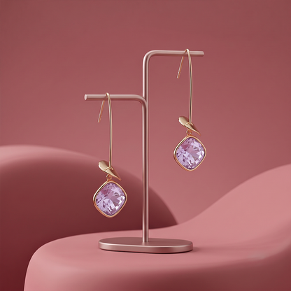 Gold plated lavender gemstone drop earrings with delicate leaf detail displayed on a jewelry stand