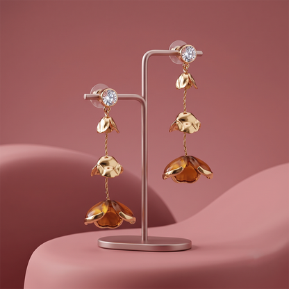 Gold plated floral drop earrings with crystal studs and layered flower charms displayed on jewelry stand