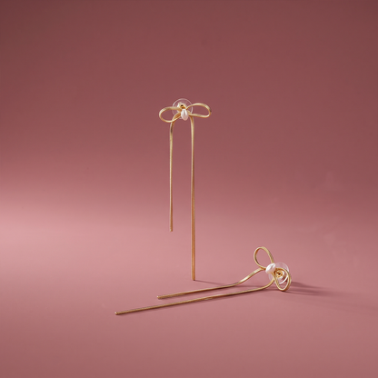 Gold plated bow drop stud earrings with pearl accent and uneven hanging chains