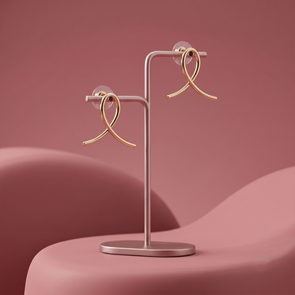 Gold plated loop drop earrings with sleek curved design displayed on a jewelry stand