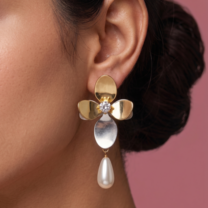 Close-up of gold plated flower earrings with crystal center, mixed metal petals and pearl drop worn on ear
